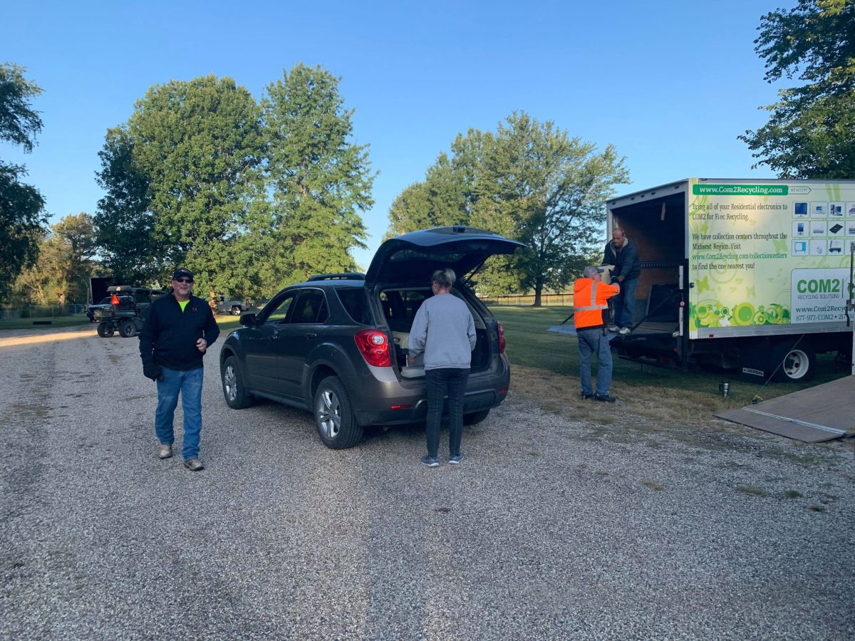 Volunteers help a resident drop off electronics at the Annual recycle day